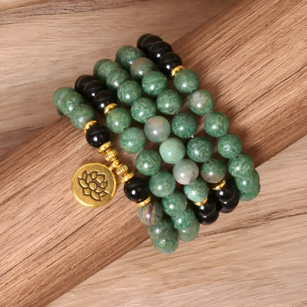 Green and black alloy elastic beaded bracelet with charm decorations on a stretch band.