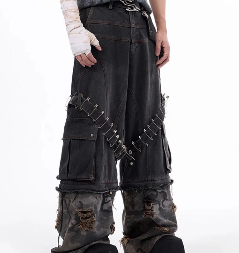 Men's grey cotton jeans with camouflage pattern splicing and decorative pin and ribbon details on the legs.