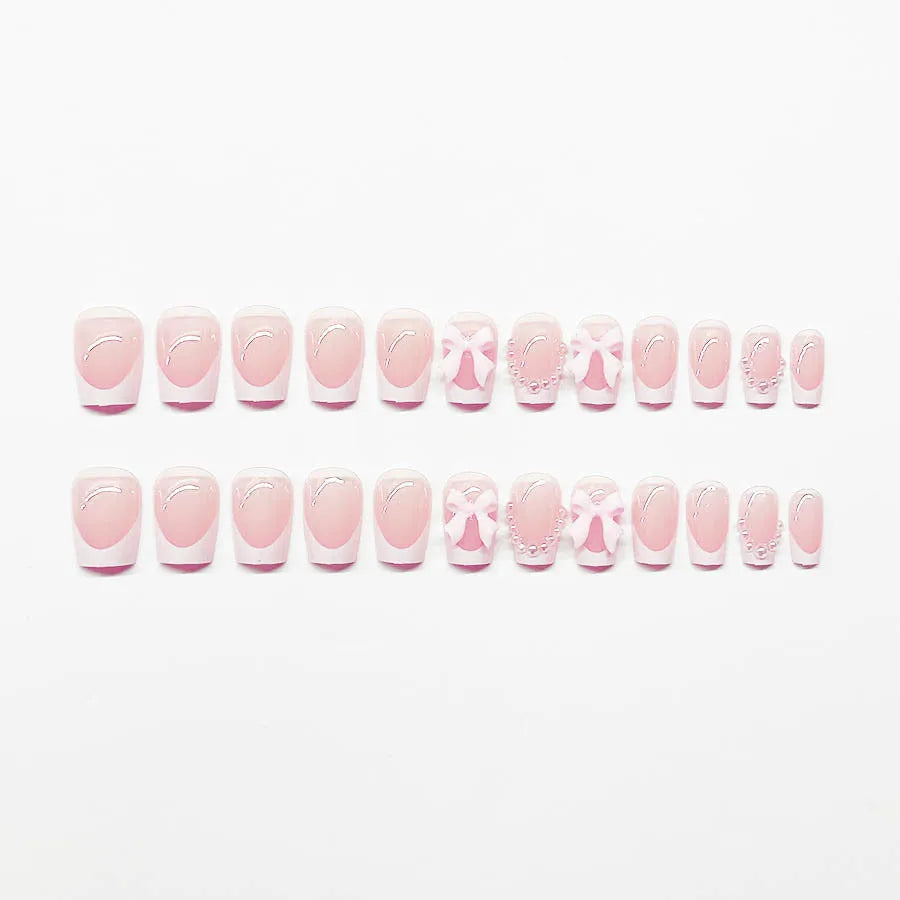 Short white French manicure press-on nails with decorative bow designs and European square shape