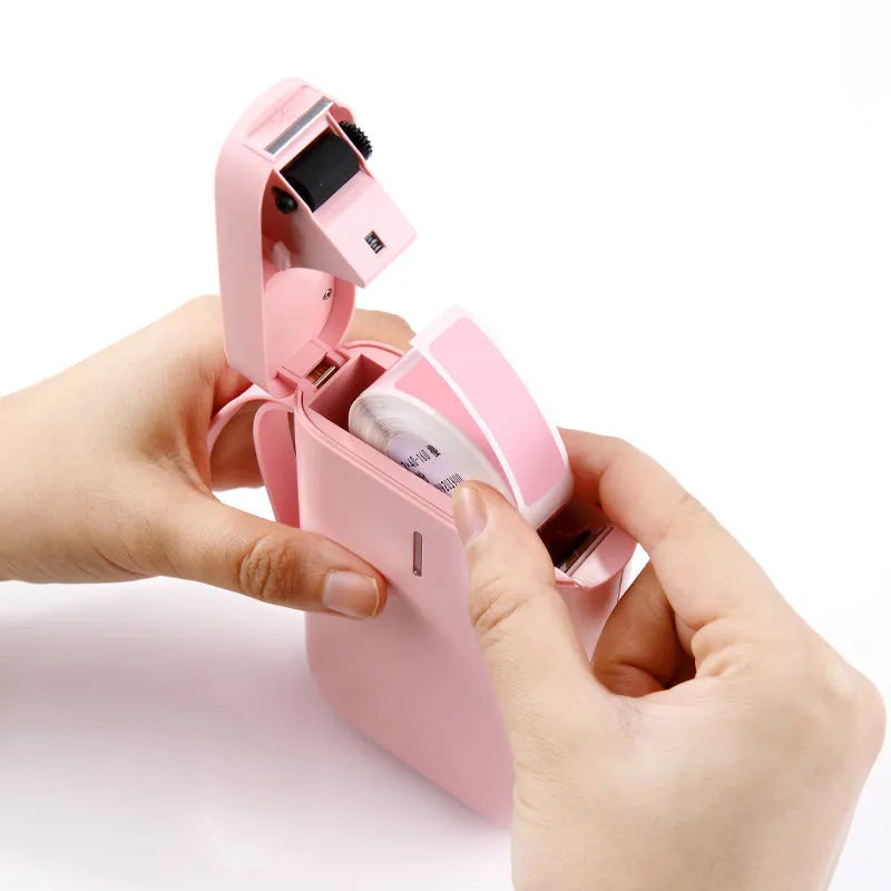 D11 Bluetooth thermal label printer in black, white, pink, or green, shown next to a smartphone running the label design app.