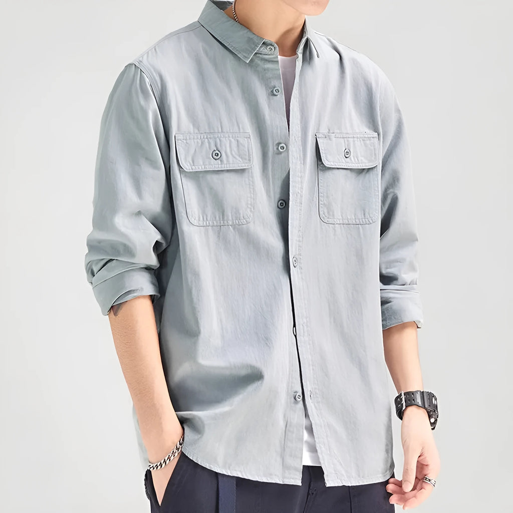 A man wearing a loose fit light grey long sleeve polyester cardigan shirt