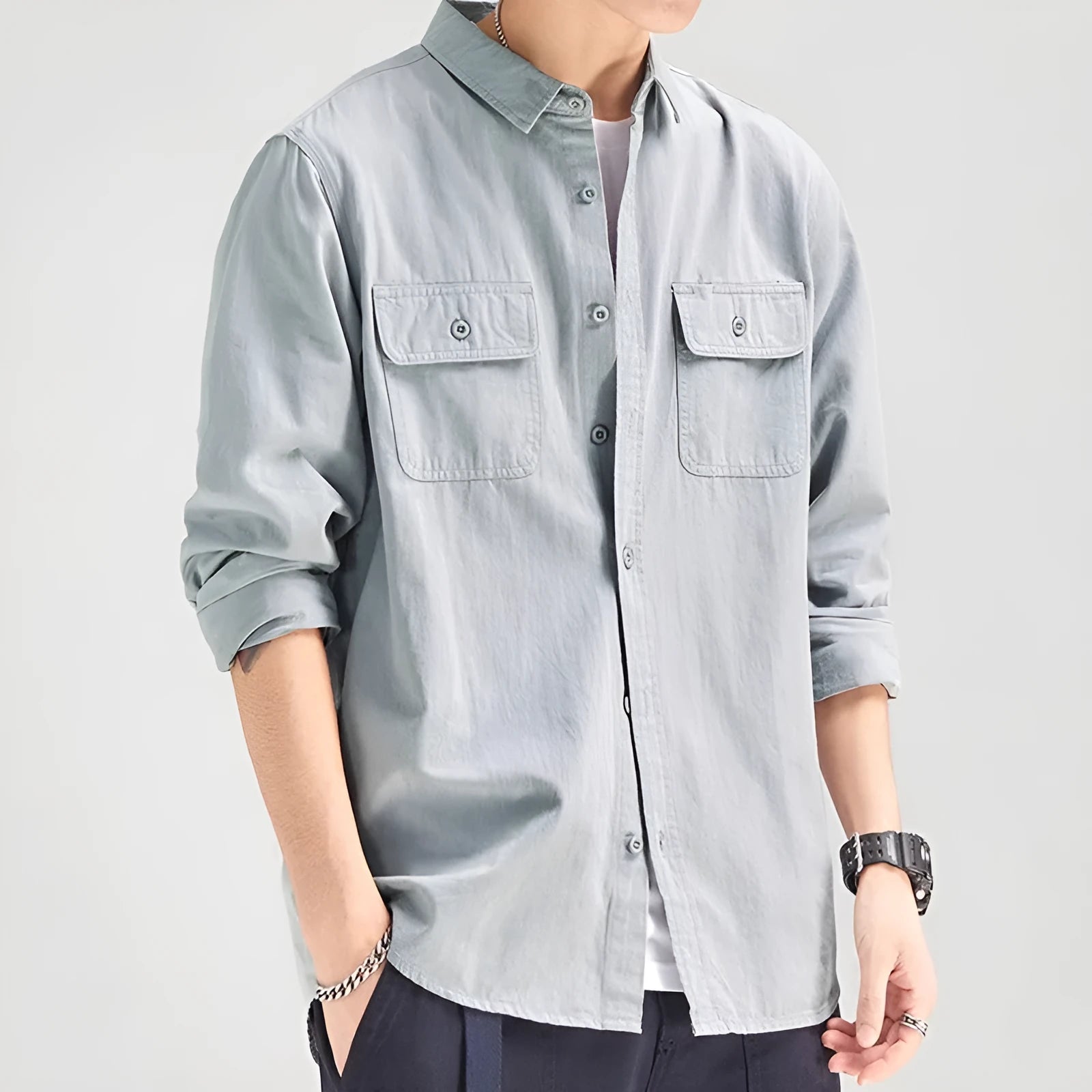 A man wearing a loose fit light grey long sleeve polyester cardigan shirt