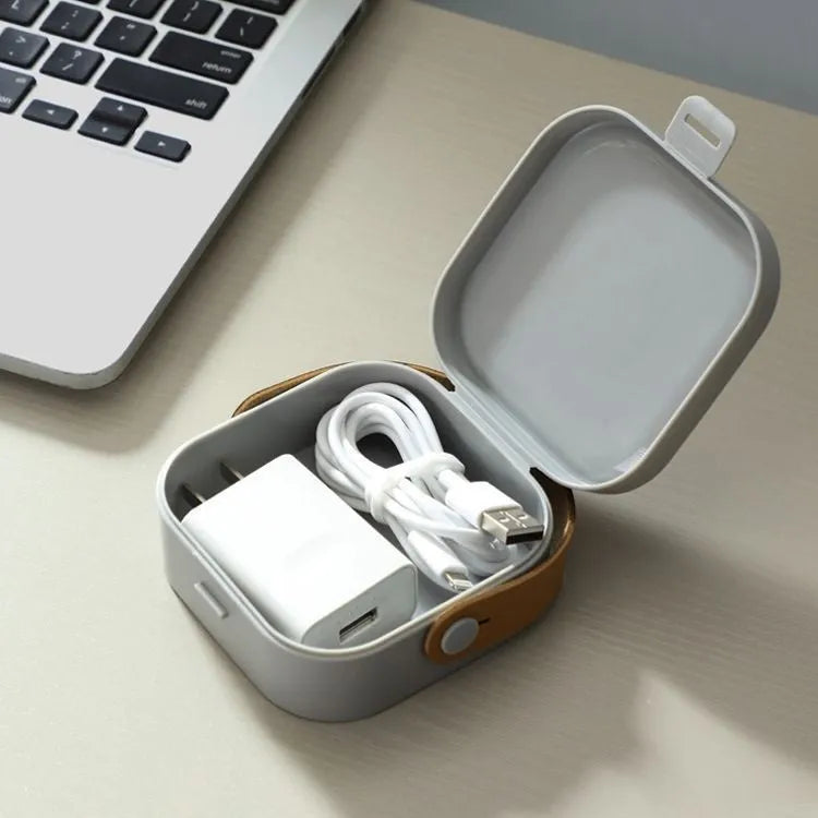 Medium-sized polypropylene storage box with a lid for organising cables and a Bluetooth headset.