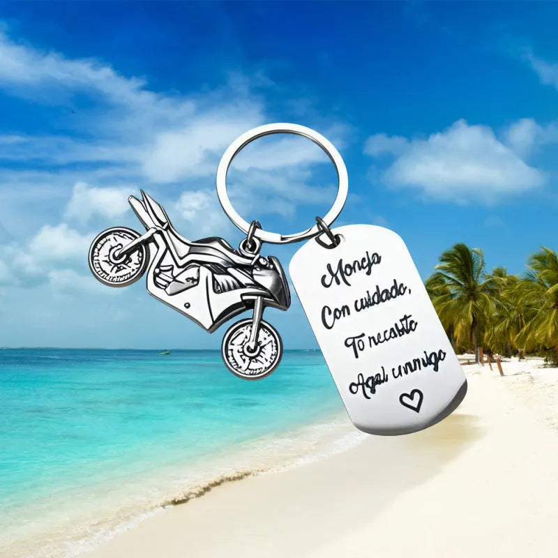 Stainless steel motorcycle-themed keychain with inspirational text alongside a flannel storage pouch.