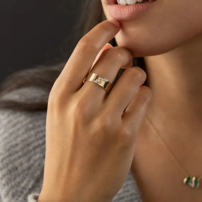 Gold-colour women's ring with shining zircon stone on copper base