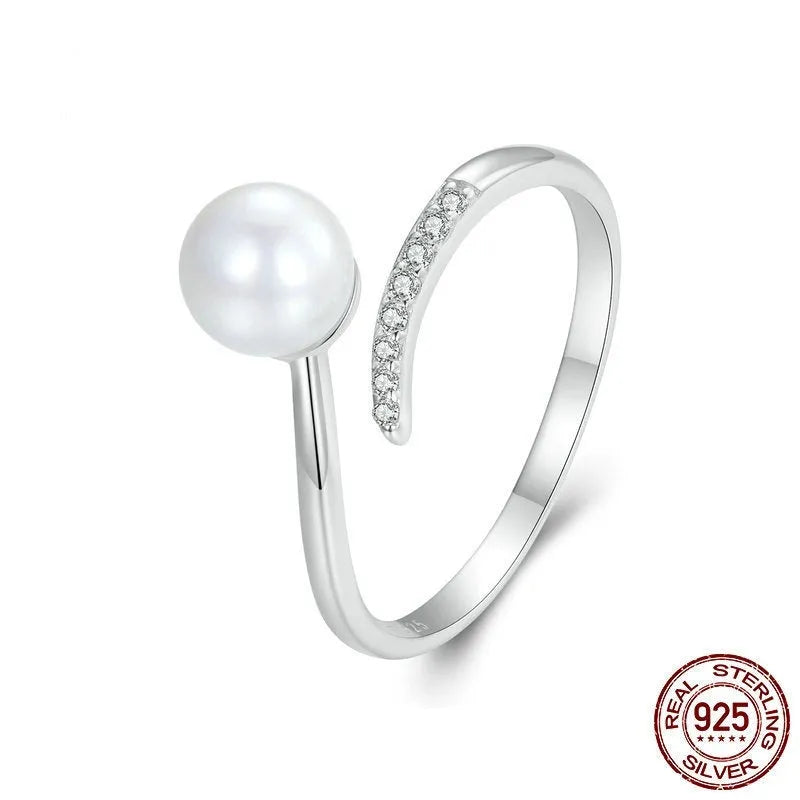 Sterling silver adjustable ring with a natural pearl on an open loop band.