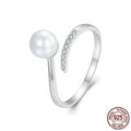 Sterling silver adjustable ring with a natural pearl on an open loop band.