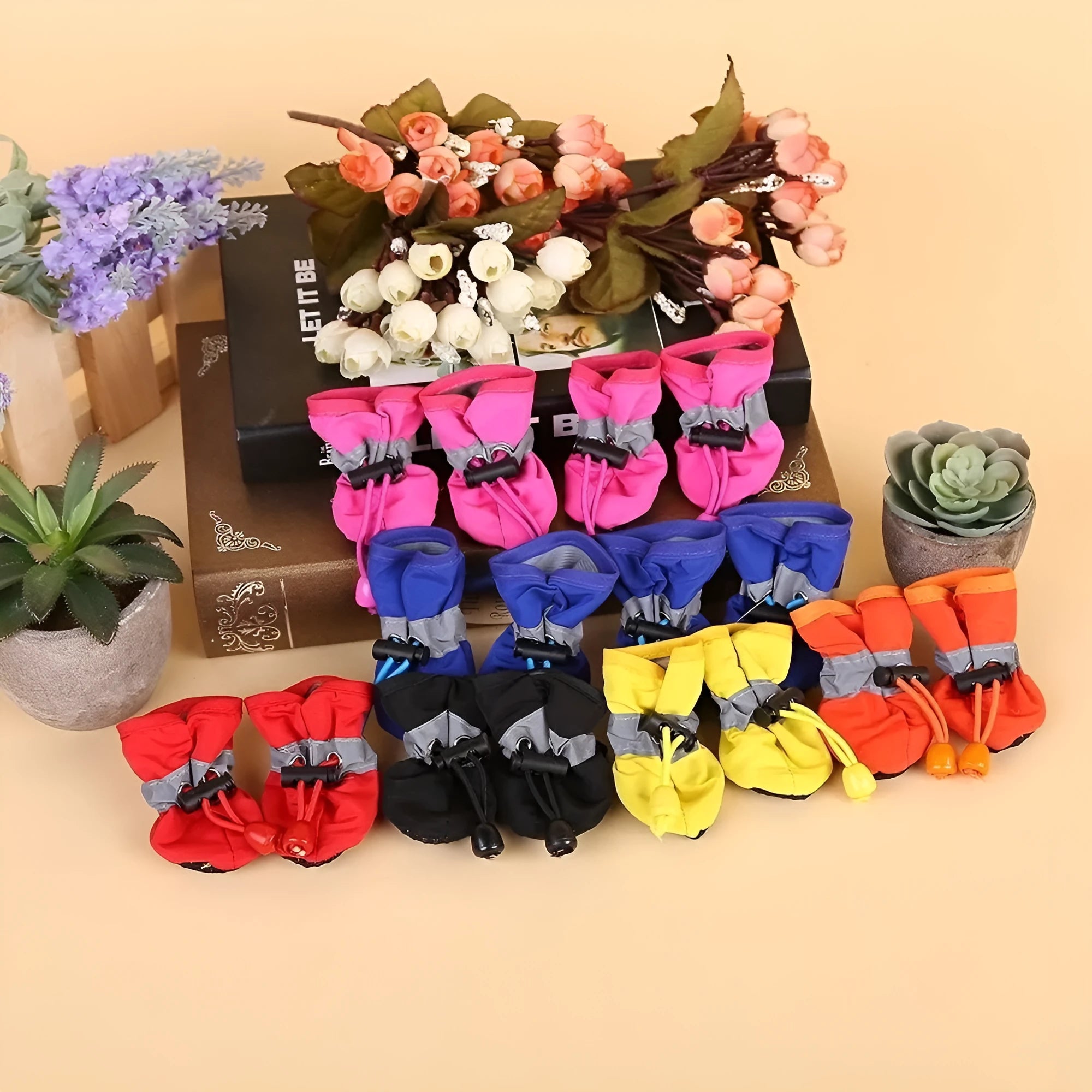 Multicolour set of four breathable cloth dog shoes with non-slip soft bottom on a white background