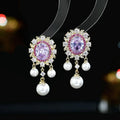 Oval geometric copper earrings with inlaid zircon centre and white pearl tassel drop in light purple colour.