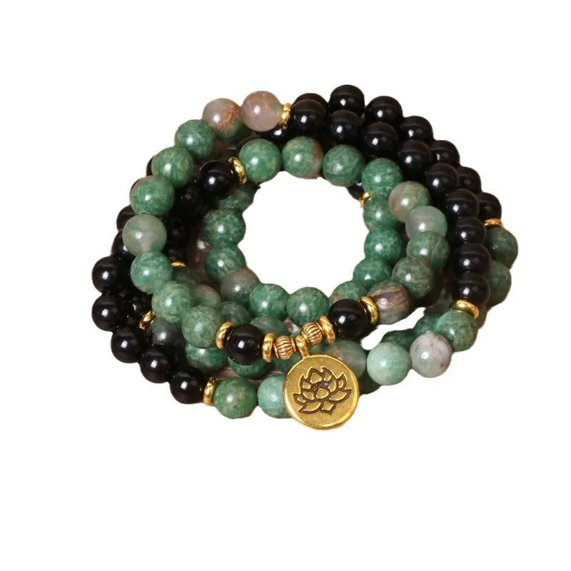 Green and black alloy elastic beaded bracelet with charm decorations on a stretch band.