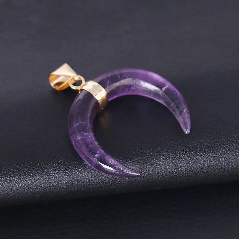 Close-up of a moon-shaped pendant necklace made from pink natural crystal stone on a 45cm electroplated copper chain.