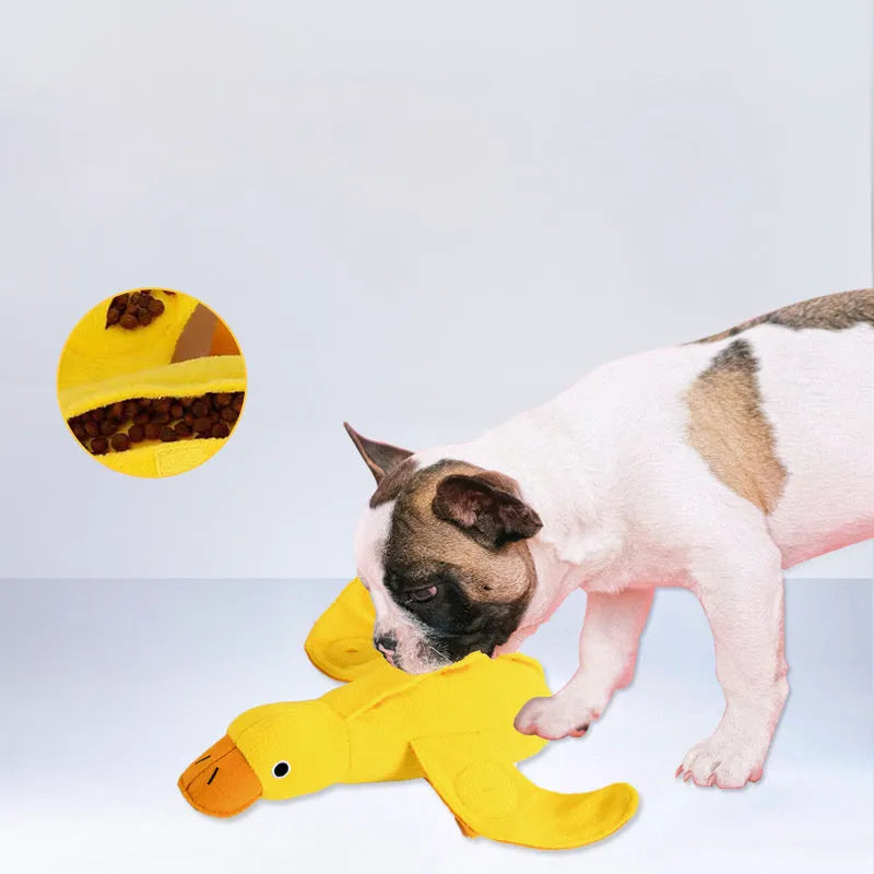 Yellow plush duck dog toy with squeaker and treat dispensing holes for training and chewing.
