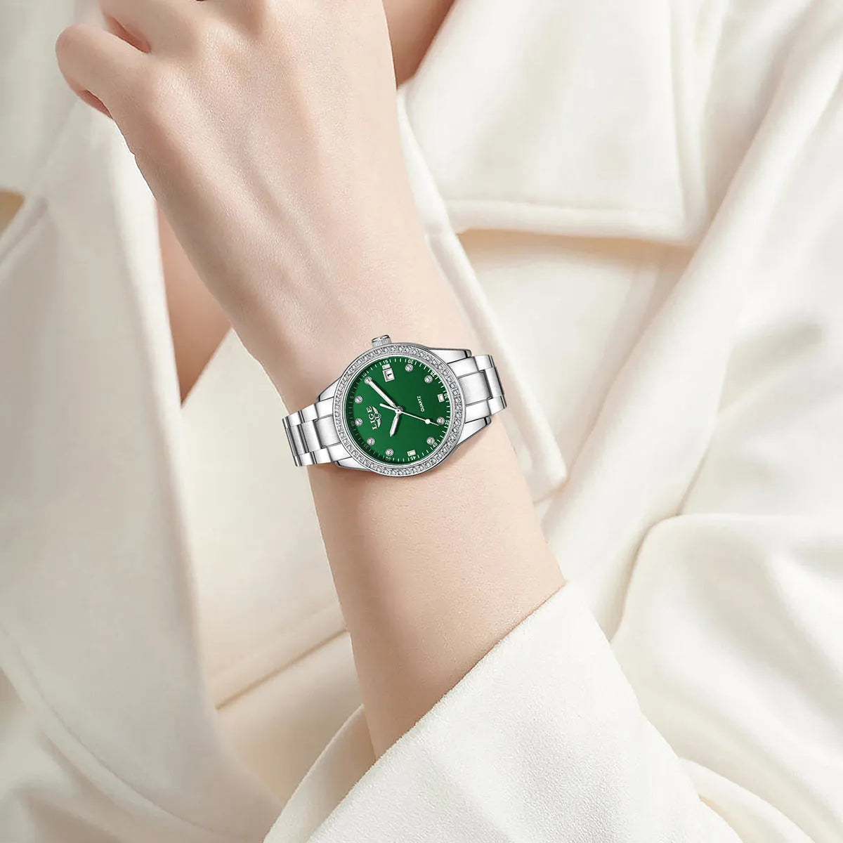 Silver stainless steel ladies watch with diamond bezel, luminous hands, and round 34mm dial.