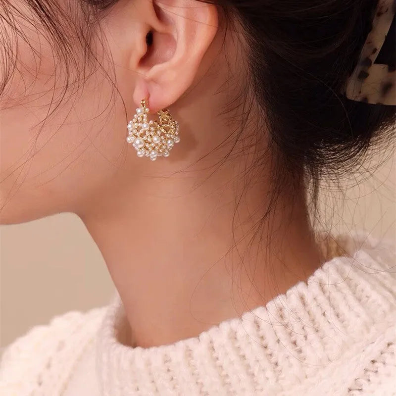 Gold tone copper flower basket shaped earrings with small rice-shaped pearl inlay beads.