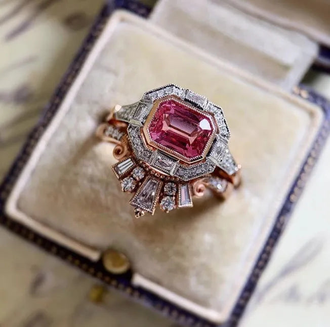 Women's rose gold colour alloy ring with geometric ruby-coloured centrepiece on finger