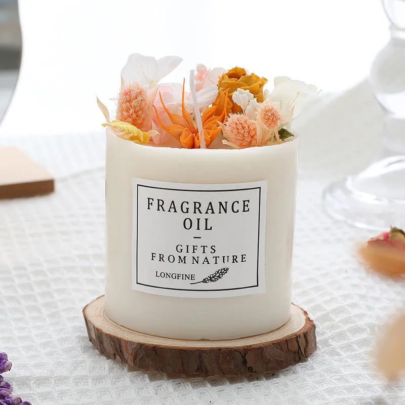 Decorative aromatherapy candle with dried flowers on top, shown in a choice of scents next to its wooden chip base and gift box.
