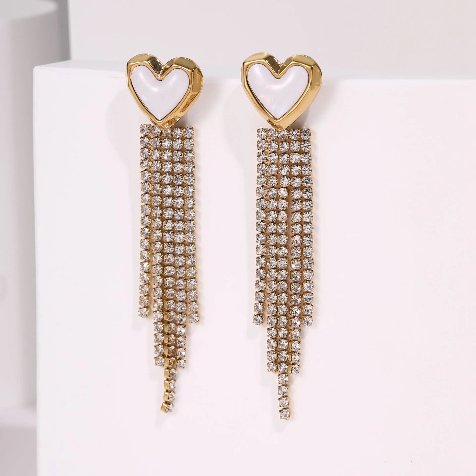 A pair of gold electroplated stainless steel earrings featuring geometric heart and five-pointed star shapes in a dangle style.