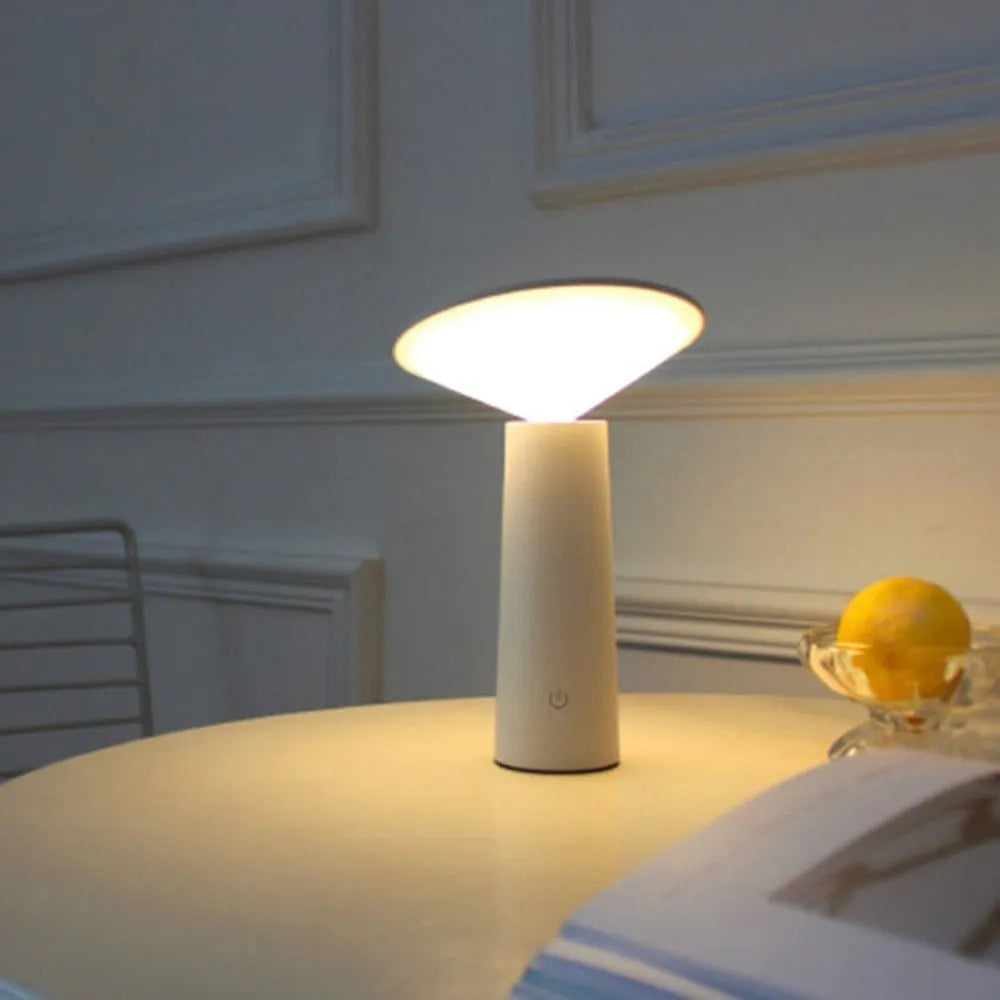 Black or white USB rechargeable LED desk lamp with touch sensor and adjustable head on a desk.