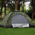 Green camouflage two-person dome tent with mesh panels and guylines pitched outdoors.