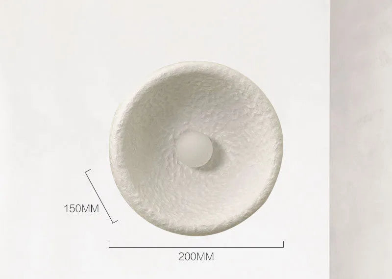 Japanese-style minimalist wall lamp with resin shade in three diameter sizes on white wall