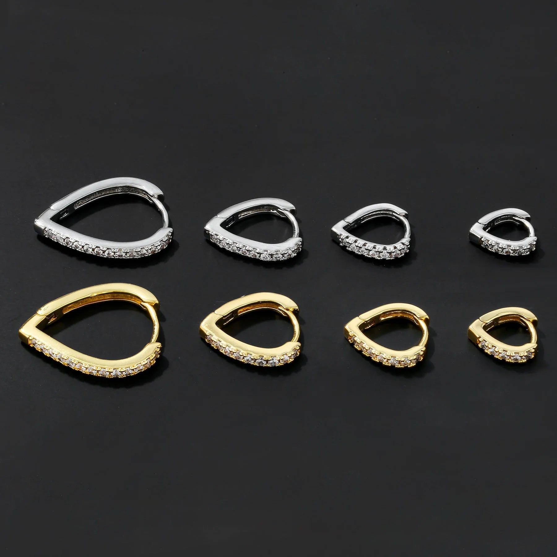 Geometric gold tone love heart clip-on earring for women on a white background.