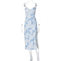 Women's long dress with lace flower print, high split, and suspender straps in blue colour.