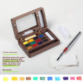 Miniature walnut wood watercolour paint box open to show 24 half-pan pigments and mixing areas
