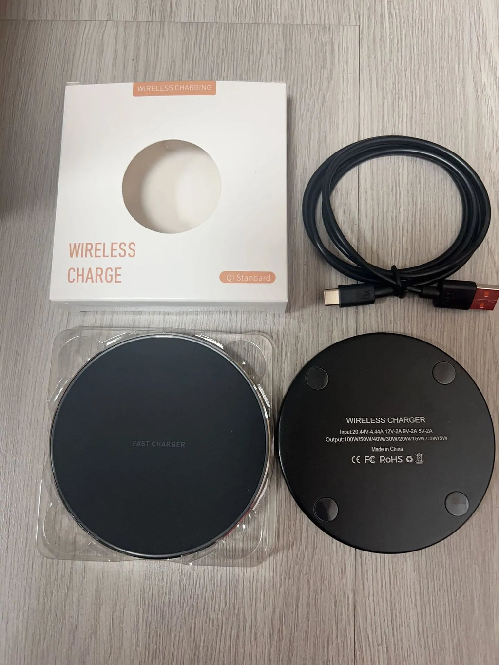 Black frosted 15W wireless charger for mobile phones with Type-C cable on a desk