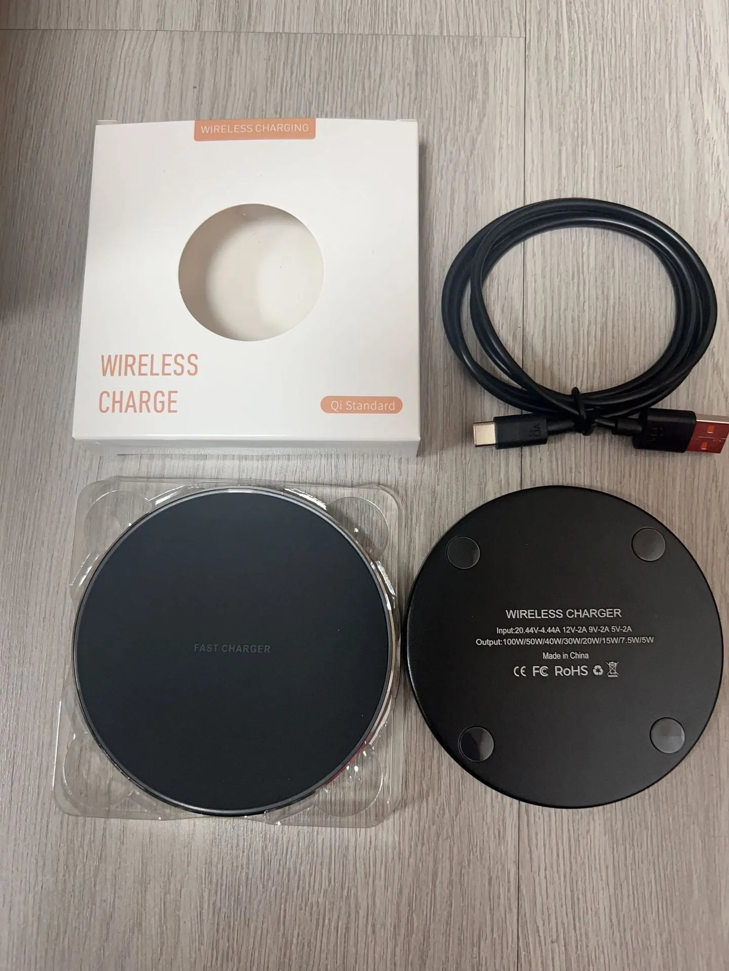 Black frosted 15W wireless charger for mobile phones with Type-C cable on a desk