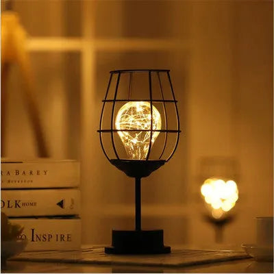 Minimalist hollow table lamp with wrought iron shell in red wine glass style emitting warm white LED light
