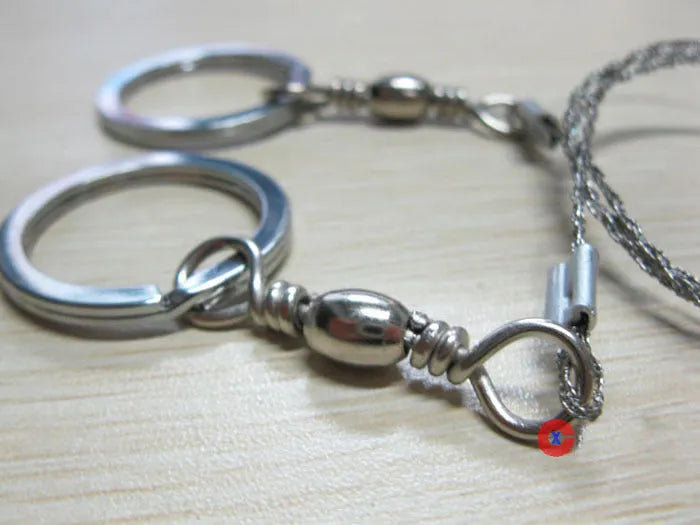 Stainless steel survival wire saw with thumb rings showing 55cm blade and compact storage size