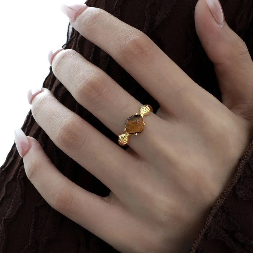 Women's adjustable silver ring with a shell design and set tiger eye gemstone in a gold colour finish.