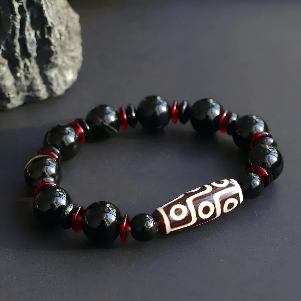 Hand-woven black agate Dzi bead bracelet with 11mm geometric beads on a wrist