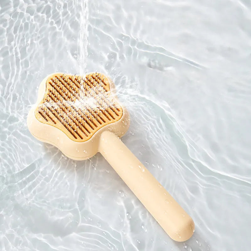 Green handled self-cleaning pet comb with stainless steel teeth on a white background.