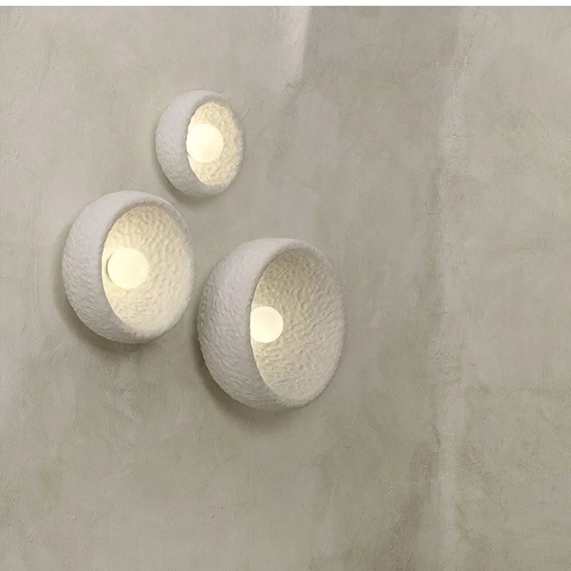 Japanese-style minimalist wall lamp with resin shade in three diameter sizes on white wall