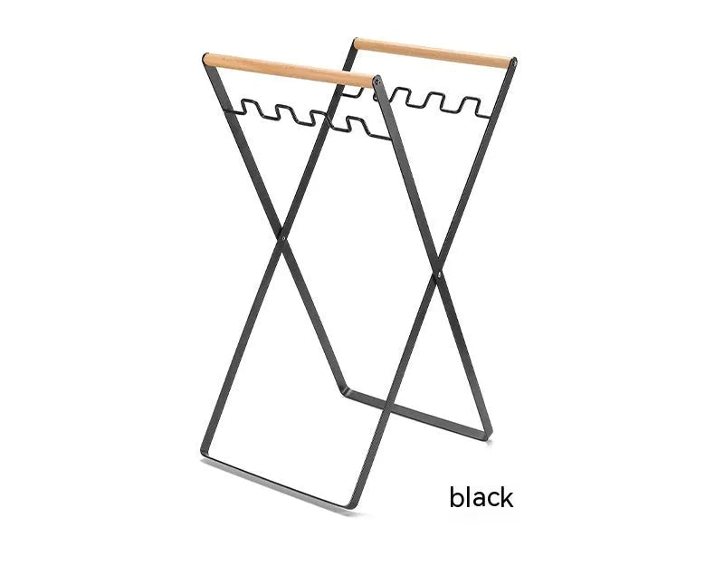 Black outdoor iron trash hanger with wooden handle in a folded position.