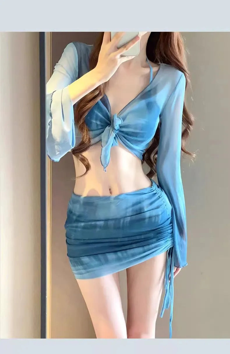 Women's blue high-waist bikini set with shirt, bra, underwear, and skirt laid flat.