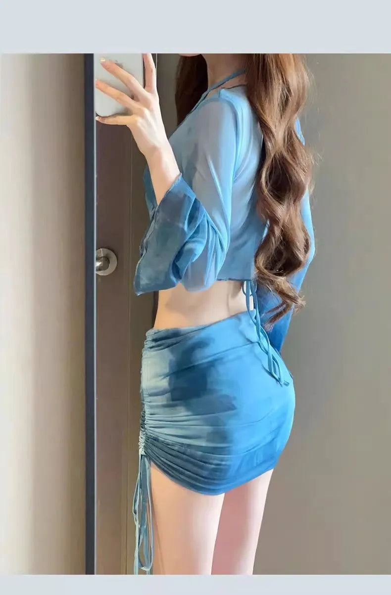 Women's blue high-waist bikini set with shirt, bra, underwear, and skirt laid flat.