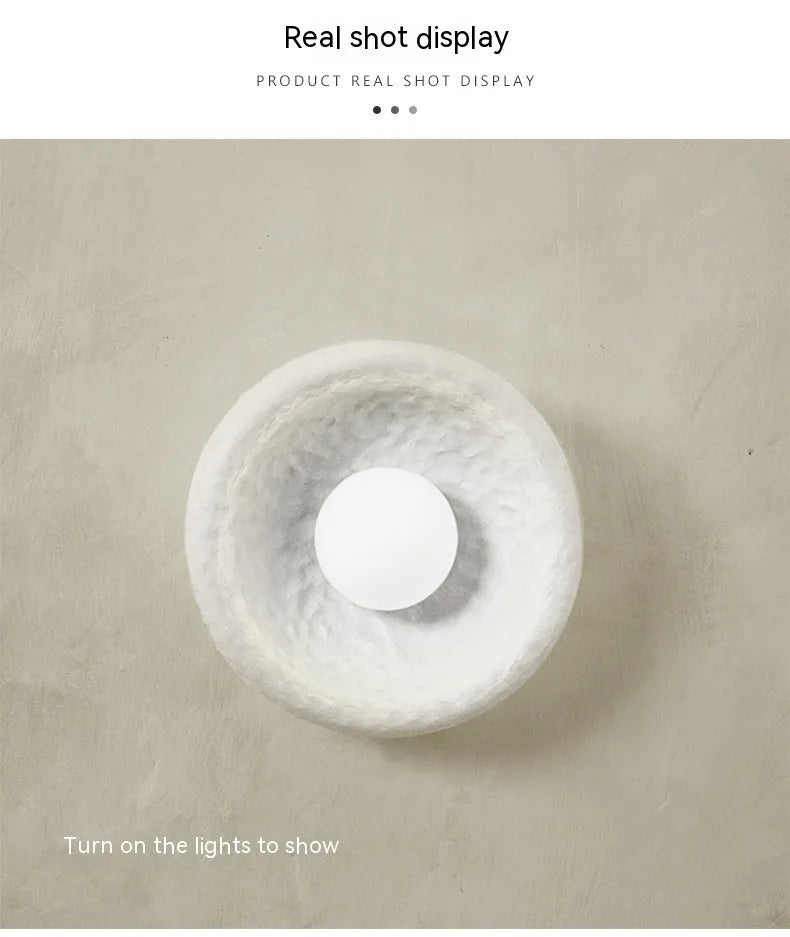 Japanese-style minimalist wall lamp with resin shade in three diameter sizes on white wall