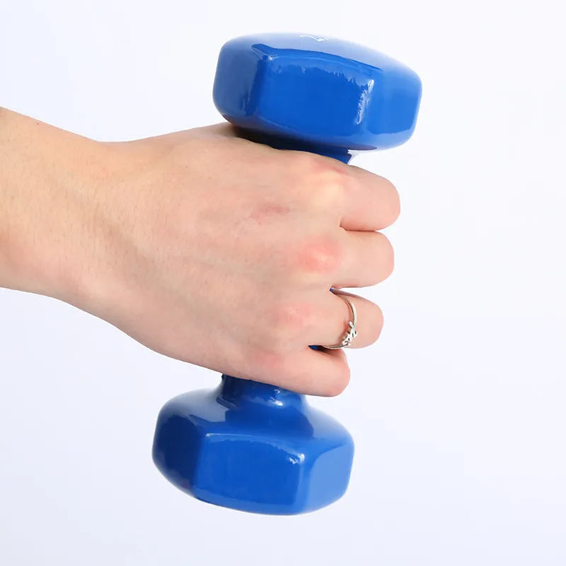 Bright colourful plastic dumbbell for fitness with glossy surface on wooden floor