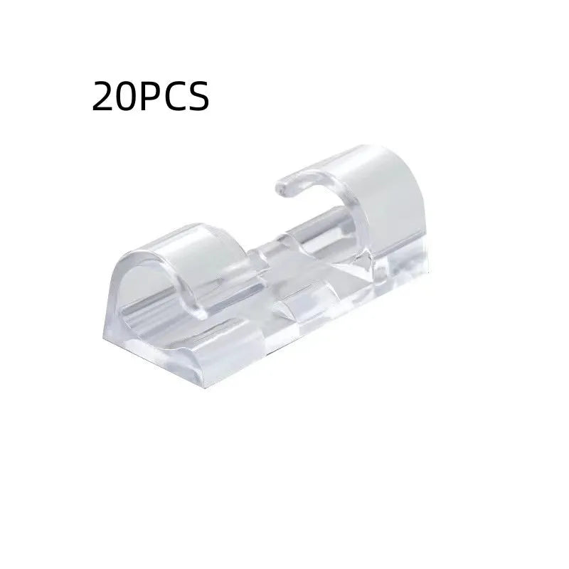 Transparent plastic self-adhesive wire holder routing snap clip on a desk surface with a white cable inserted