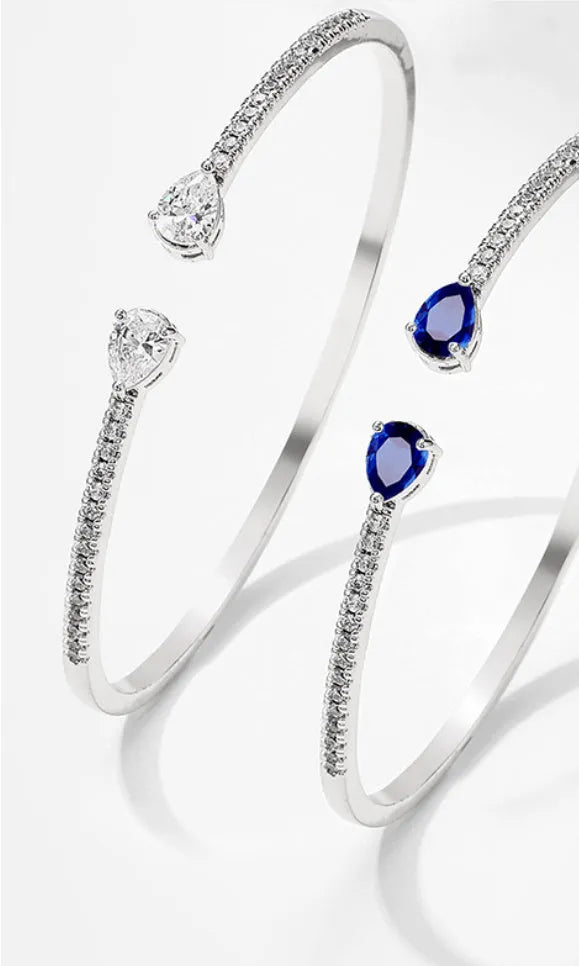 Copper bracelet with inlaid zircon detailing in simple style, shown in white and blue colour options.