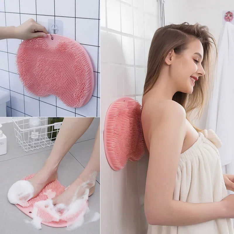 Orange massage bath brush with silicone bristles and suction cup base on a shower floor