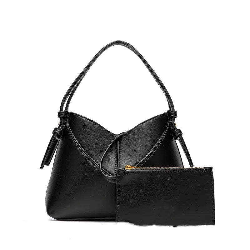 Trendy solid colour stitched oval handbag and crossbody bag for women in black with single shoulder strap and interior slip pocket