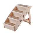 Foldable grey plastic pet stairs with non-slip steps next to a sofa