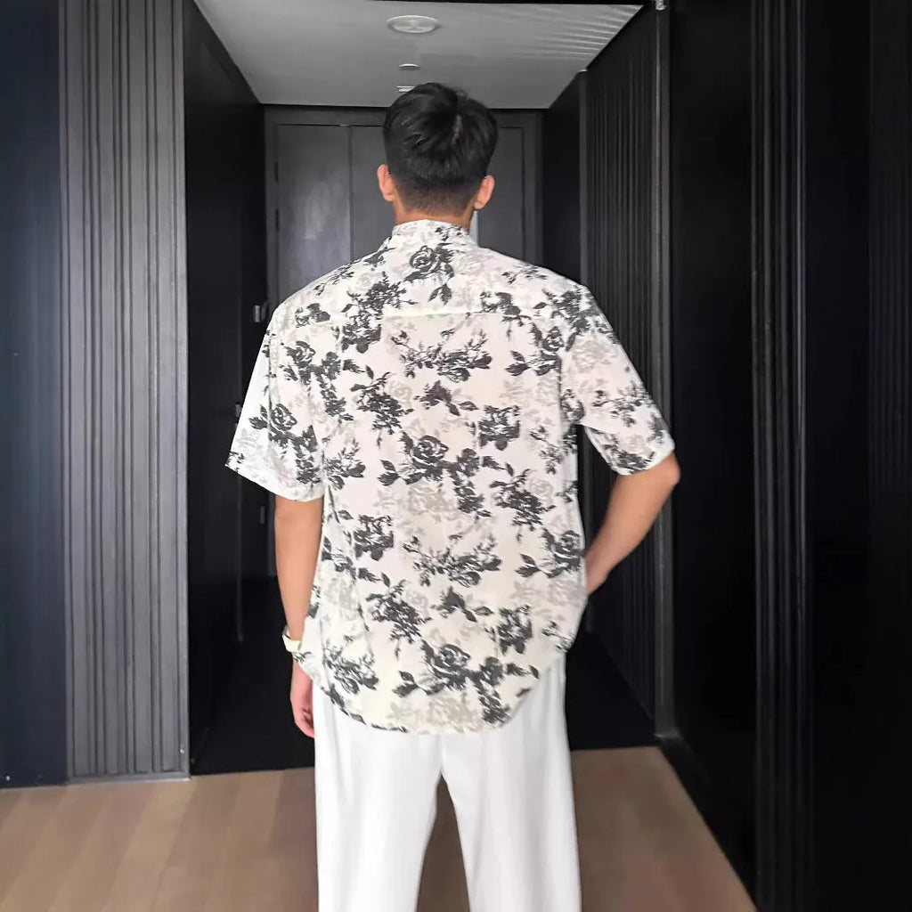 Loose black and white floral print short sleeve casual shirt on a hanger.