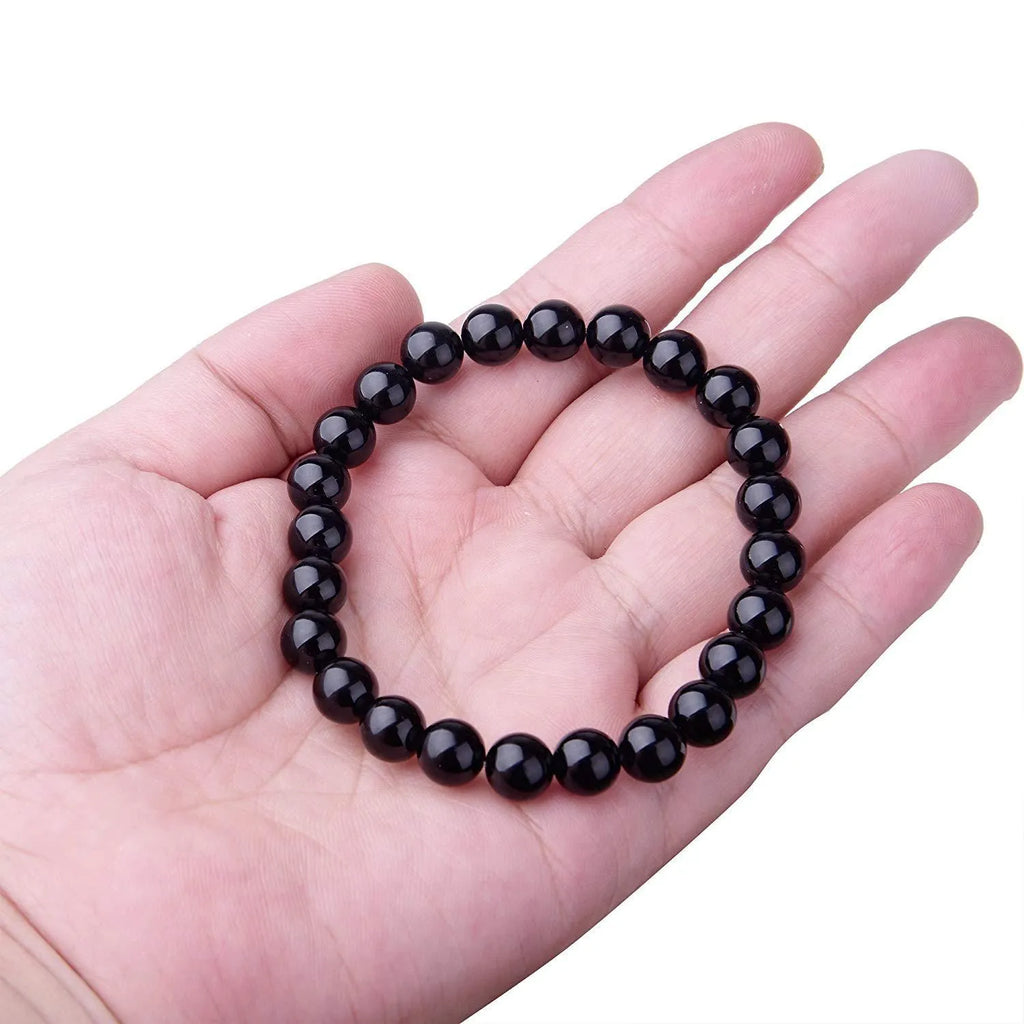 Women's black onyx agate beaded bracelet with geometric design and elastic cord.