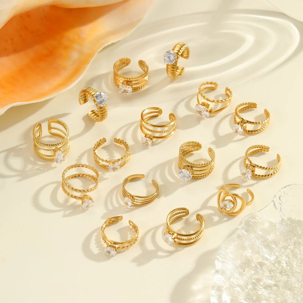 Gold electroplated geometric stainless steel ring with inlaid zircon stones on a finger, showing open mouth design.