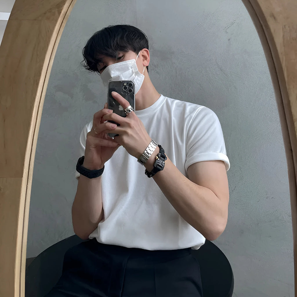 Men's slim fit cotton T-shirt in black on a hanger, showing round neck and regular sleeve.