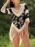Women's apricot V-neck sun protection blouse with hollow-out sleeves on a beach.